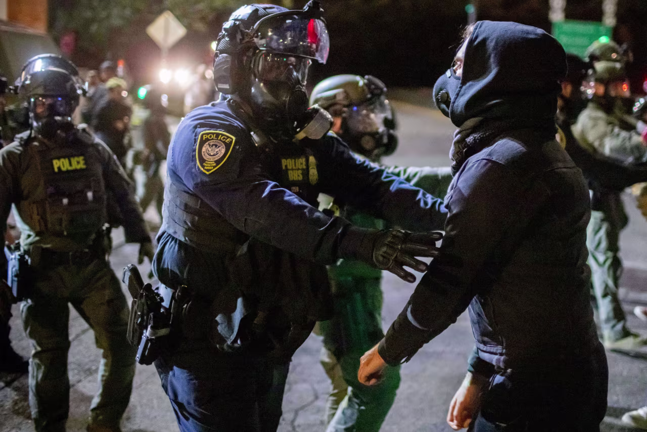 Protesters confront federal agents outside an ICE facility in Portland, Oregon, on Monday night.
