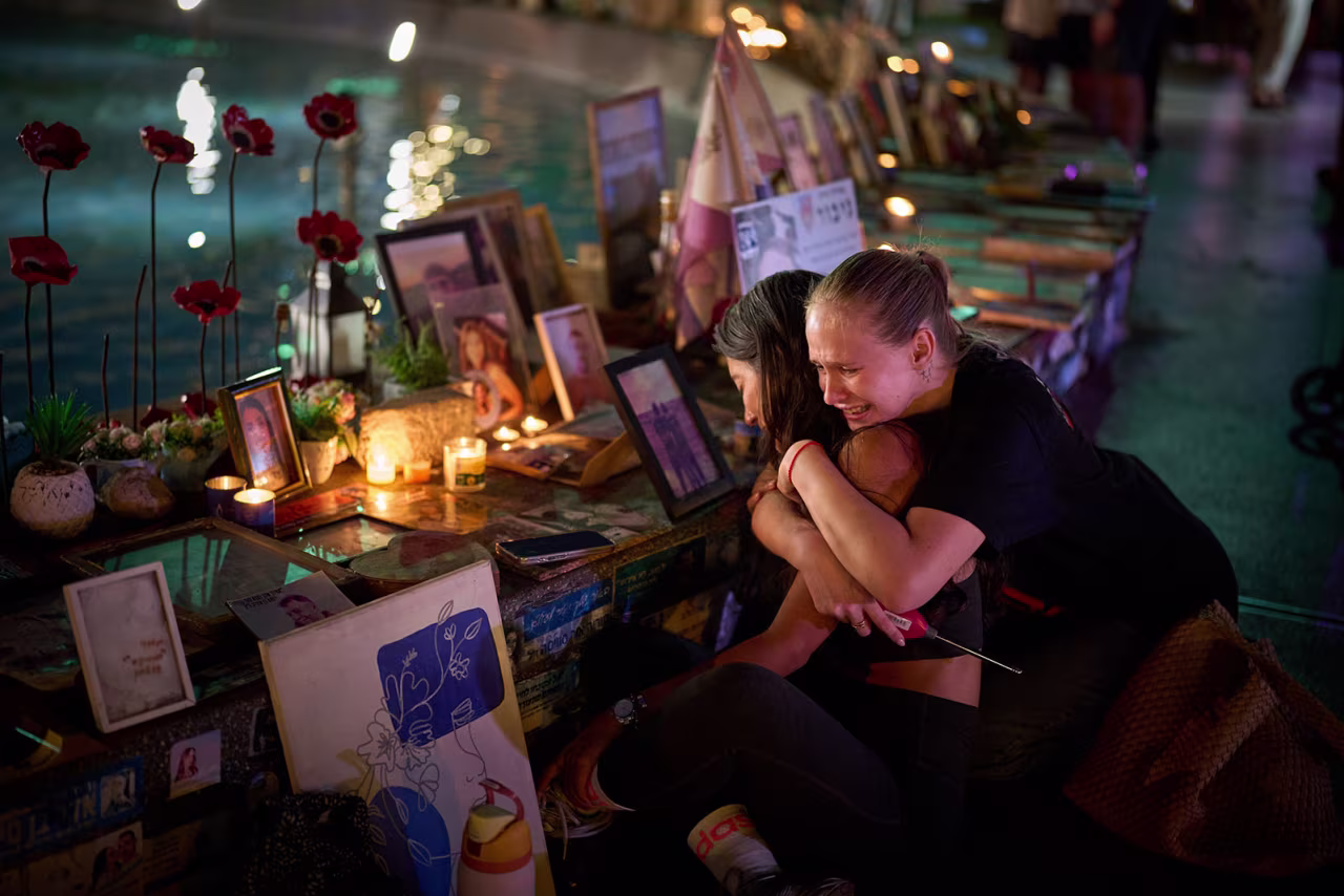 Yuval Miranda and Katya Emelianova cry as they embrace next to the photographs of Israelis who were killed in the deadly October 7, 2023, Hamas attack on Israel, at a memorial marking the two-year anniversary of the assault, in Tel Aviv, Israel, on Tuesday.
