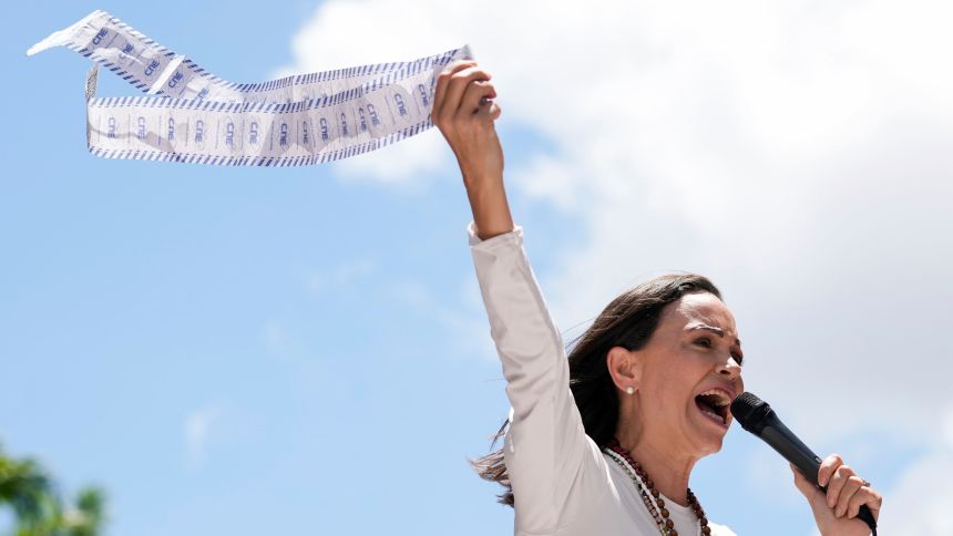 FILE - Opposition leader Maria Corina Machado holds up tally sheets during a protest against the reelection of President Nicolás Maduro one month after the disputed presidential vote which she says the opposition won by a landslide, in Caracas, Venezuela, Aug. 28, 2024. (AP Photo/Ariana Cubillos, File)