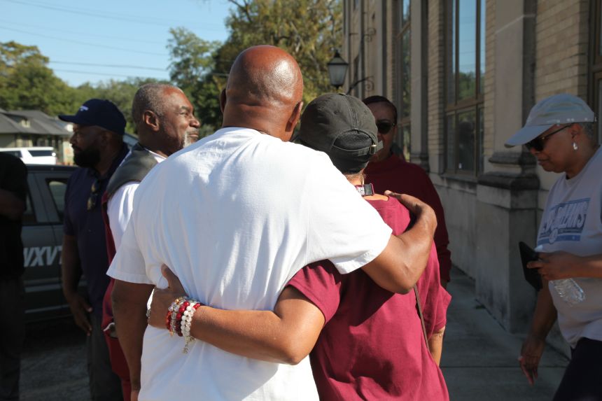 Friends and family of victims of a homecoming shooting embrace in downtown Leland, Mississippi, on Saturday.