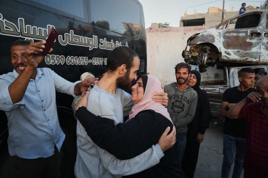 People greet freed Palestinian prisoners as they arrive in Gaza after their release from Israeli prison, outside Nasser Hospital in Khan Younis on Monday.