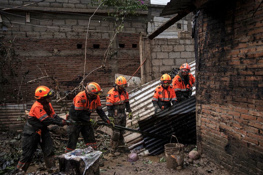 Rescue workers, part of the volunteer brigade known as the Topos, clean a damaged house in Poza Rica, Mexico, on Monday, October 13, after torrential rains.