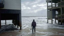 A worker reinforces a home that's at risk of falling into the ocean on October 10, 2025, in Buxton, North Carolina.