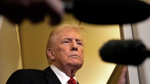 President Donald Trump speaks to reporters aboard Air Force One on Sunday, en route to Joint Base Andrews as he returns from a trip to Florida.