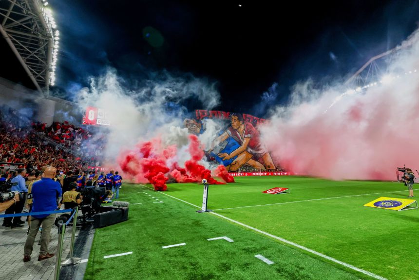 Smoke from flares thrown by fans fills the pitch before the soccer derby between Maccabi Tel Aviv and Hapoel Tel Aviv was called off Sunday.