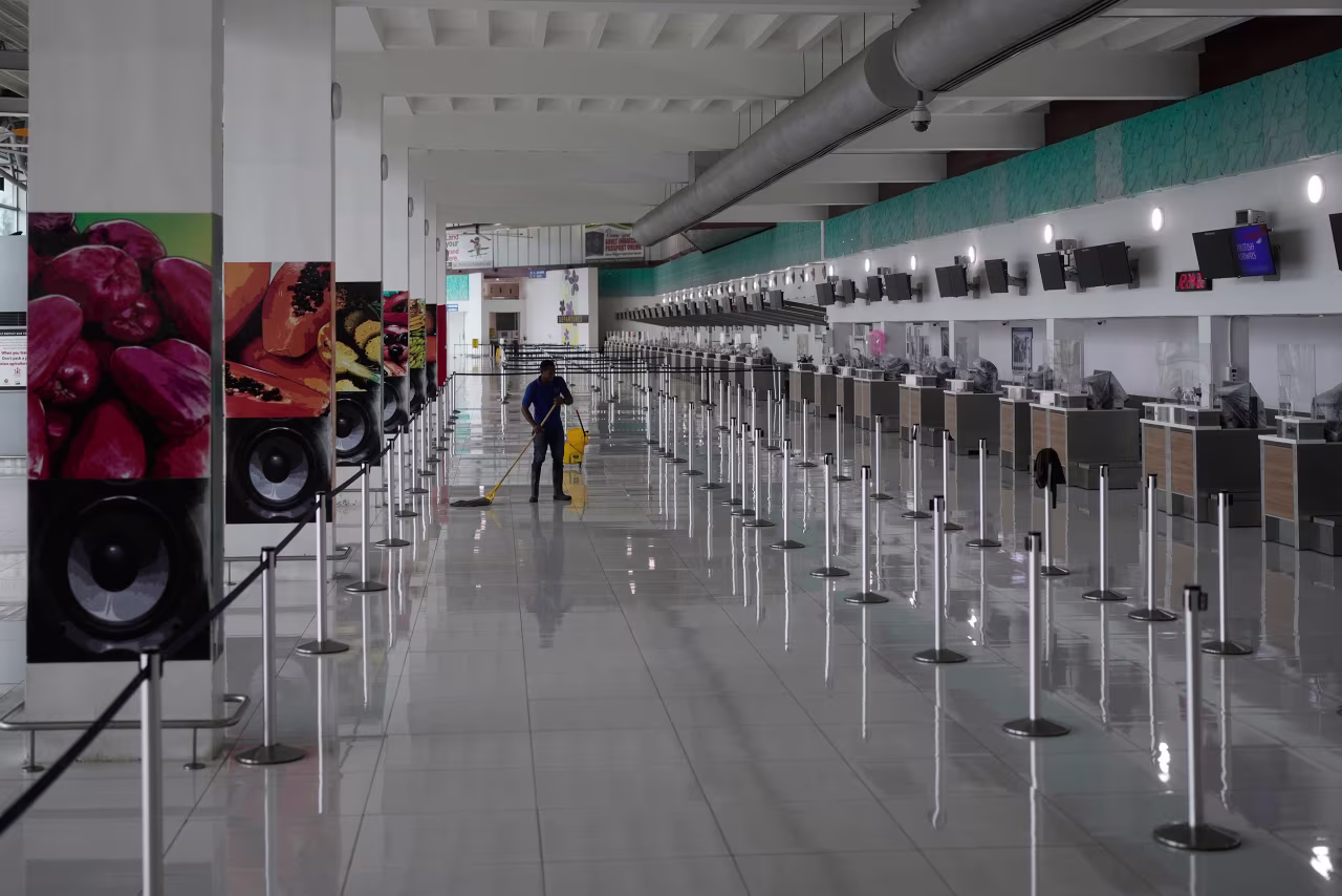 A janitor mops the floor at Norman Manley International Airport in Kingston on Sunday, October 26, before the arrival of Hurricane Melissa.