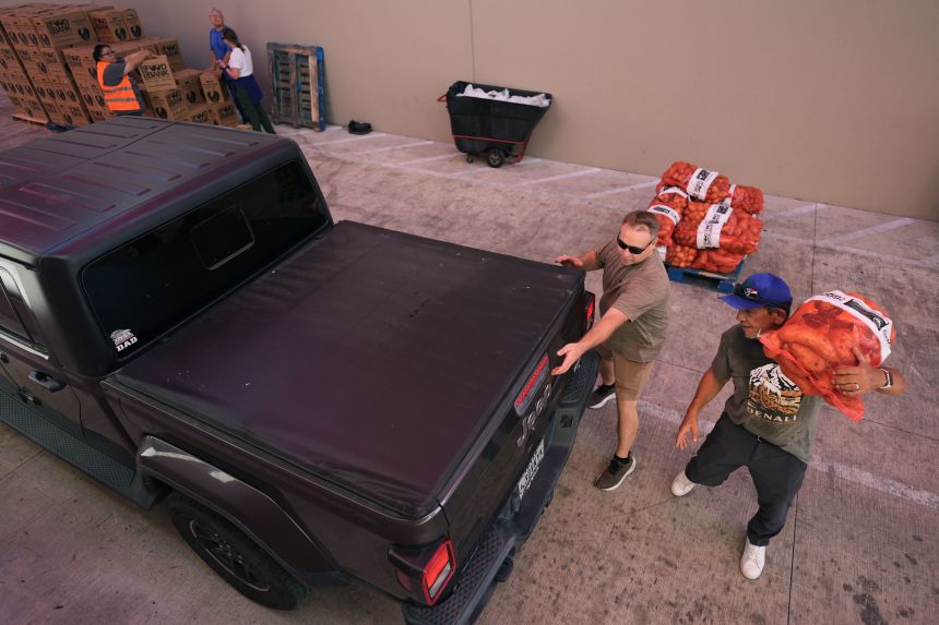 Volunteers help load a vehicle during a food distribution targeting federal employees and SNAP recipients in October in San Antonio.