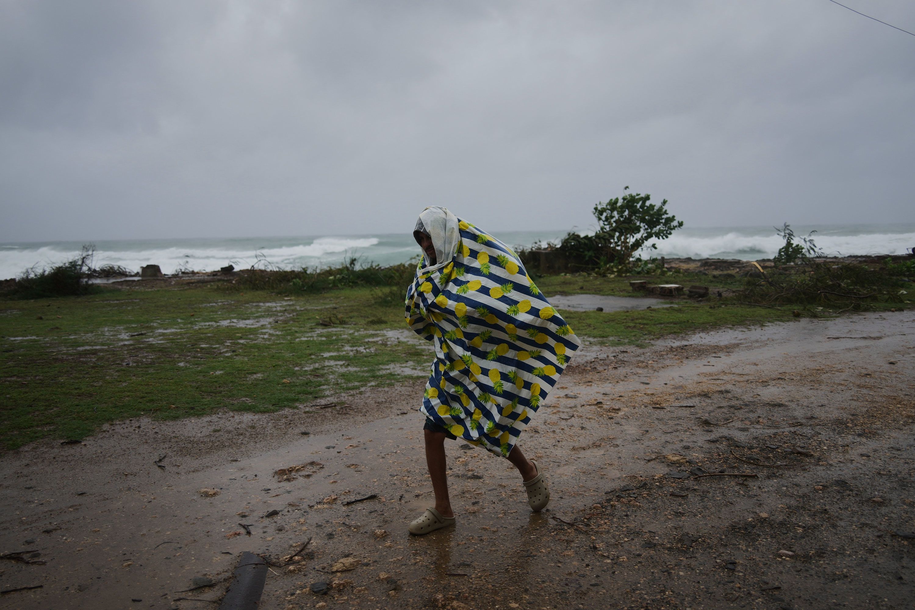 A man walks in the rain before the arrival of Hurricane Melissa in Canizo, a village in Santiago de Cuba, on October 28.