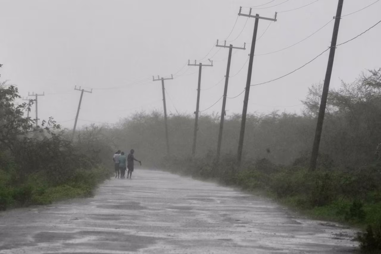 People walk along a road during the passing of Hurricane Melissa in Rocky Point, Jamaica, on Tuesday.