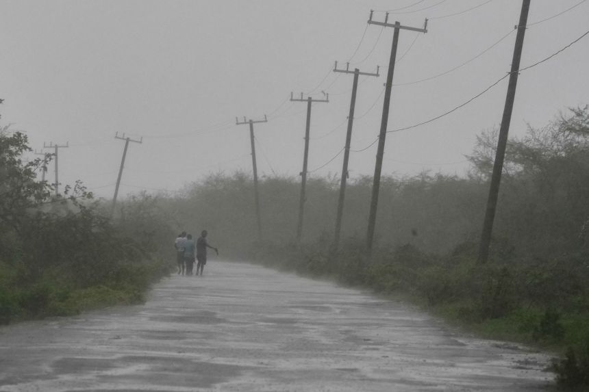 People walk along a road during the passing of Hurricane Melissa in Rocky Point, Jamaica, on Tuesday.