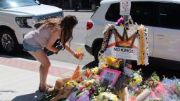 A woman lays flowers at a makeshift memorial for Arthur Folasa Ah Loo, known to friends and family as Afa, on the city block in Salt Lake City, where Ah Loo was fatally shot during a "No Kings" protest, in Salt Lake City, Utah, June 17, 2025.