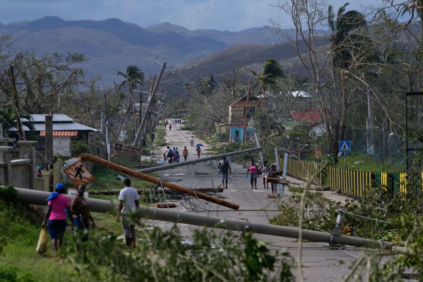 Residents walk in Lacovia Tombstone, Jamaica, in the aftermath of Hurricane Melissa on Wednesday.