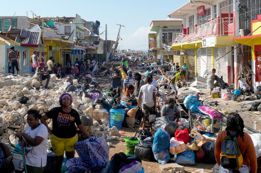 Residents gather amid debris in the aftermath of Hurricane Melissa on a street in Black River, Jamaica, Thursday, Oct. 30, 2025. (AP Photo/Matias Delacroix)