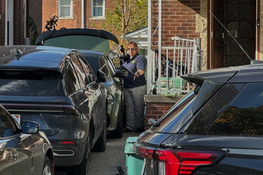 FBI agents gather outside a home in a Dearborn neighborhood on Friday.