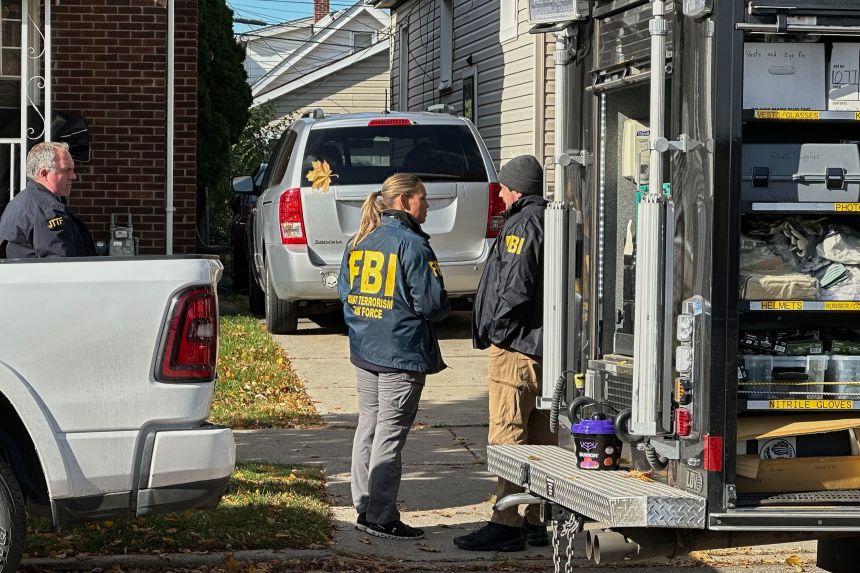 FBI agents gather outside a home in a Dearborn, Michigan, neighborhood on Friday, October 31.