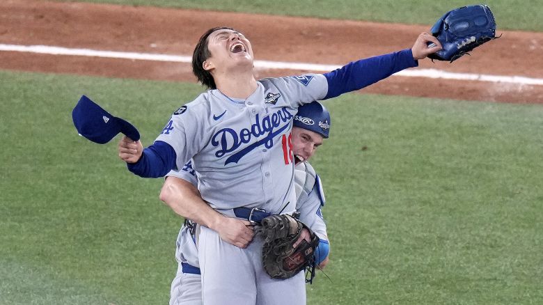 Los Angeles Dodgers pitcher Yoshinobu Yamamoto (18) celebrates with teammate Will Smith after the team defeated the Toronto Blue Jays in Game 7 of baseball's World Series, Sunday, Nov. 2, 2025, in Toronto. (Chris Young/The Canadian Press via AP)