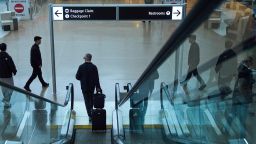 A traveler departs an escalator near a security checkpoint at Seattle-Tacoma International Airport, Thursday, Nov. 6, 2025, in SeaTac, Wash. (AP Photo/Lindsey Wasson)