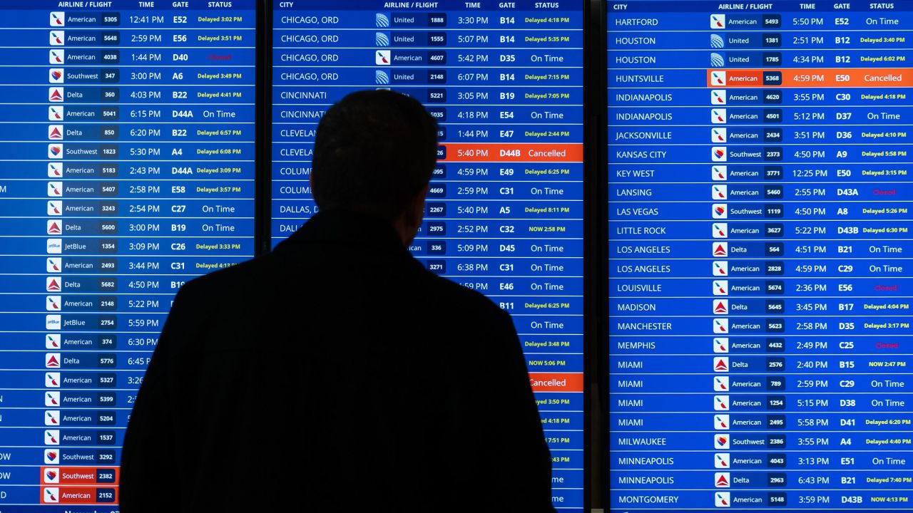 Flight delays and cancellations are shown on a flight schedule in Reagan National Airport in Arlington, Virginia, on Friday.