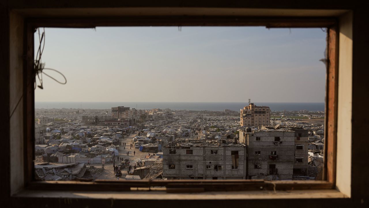 Displaced Palestinians walk through a makeshift tent camp in the Muwasi area of Khan Younis, Gaza, on November 8.
