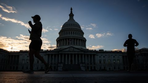 Joggers run past the US Capitol building in Washington DC, on November 10, 2025.