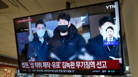 A TV screen shows a file image of Kim Nok-wan, center, the leader of a Telegram- based sex crime ring, during a news program at a express bus terminal in Seoul, South Korea, Monday, Nov. 24, 2025.