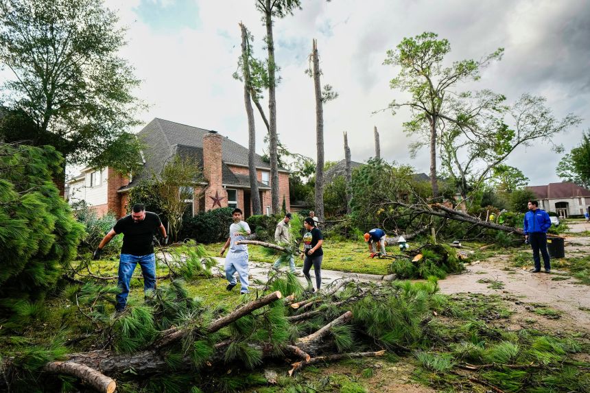 Residents clean up storm damage in Spring, Texas, on Monday.