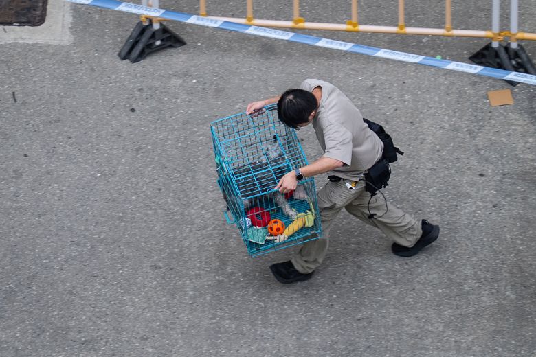 A man evacuates a pet dog in the aftermath of a fire which broke out Wednesday at Wang Fuk Court, a residential estate in the Tai Po, Hong Kong, on November 27, 2025