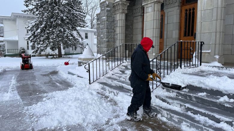 A man shovels snow outside a church in Lowville, New York, on Friday.