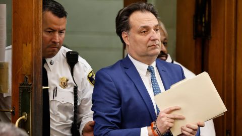 Brian Walshe enter the courtroom clutching papers and a rosary. Opening statements in the Brian Walshe murder trial in Norfolk Superior Court, Dedham, Mass., Monday, Dec. 1, 2025 (Greg Derr/The Patriot Ledger via AP, Pool)