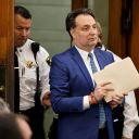 Brian Walshe enter the courtroom clutching papers and a rosary. Opening statements in the Brian Walshe murder trial in Norfolk Superior Court, Dedham, Mass., Monday, Dec. 1, 2025 (Greg Derr/The Patriot Ledger via AP, Pool)