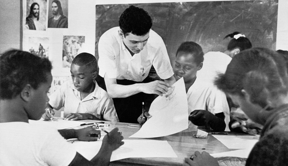 In this Aug. 23, 1964 file photo, Bruce Solomon, of the Brooklyn borough of New York, teaches a class for young Black students about arts, African American history and rights at a "Freedom School" in Jackson, Miss. Solomon was one of hundreds of volunteers in the “Mississippi Summer Project.” The classes throughout the state were set up by the volunteer workers in churches, homes and other buildings to encourage African Americans to register to vote during the long hot summer.