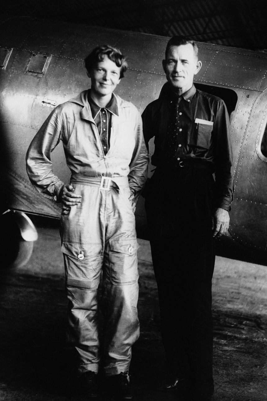 Amelia Earhart and her navigator, Fred Noonan, pose in front of their twin-engine Lockheed Electra in Natal, Brazil, June 18, 1937, during their flight around the world.