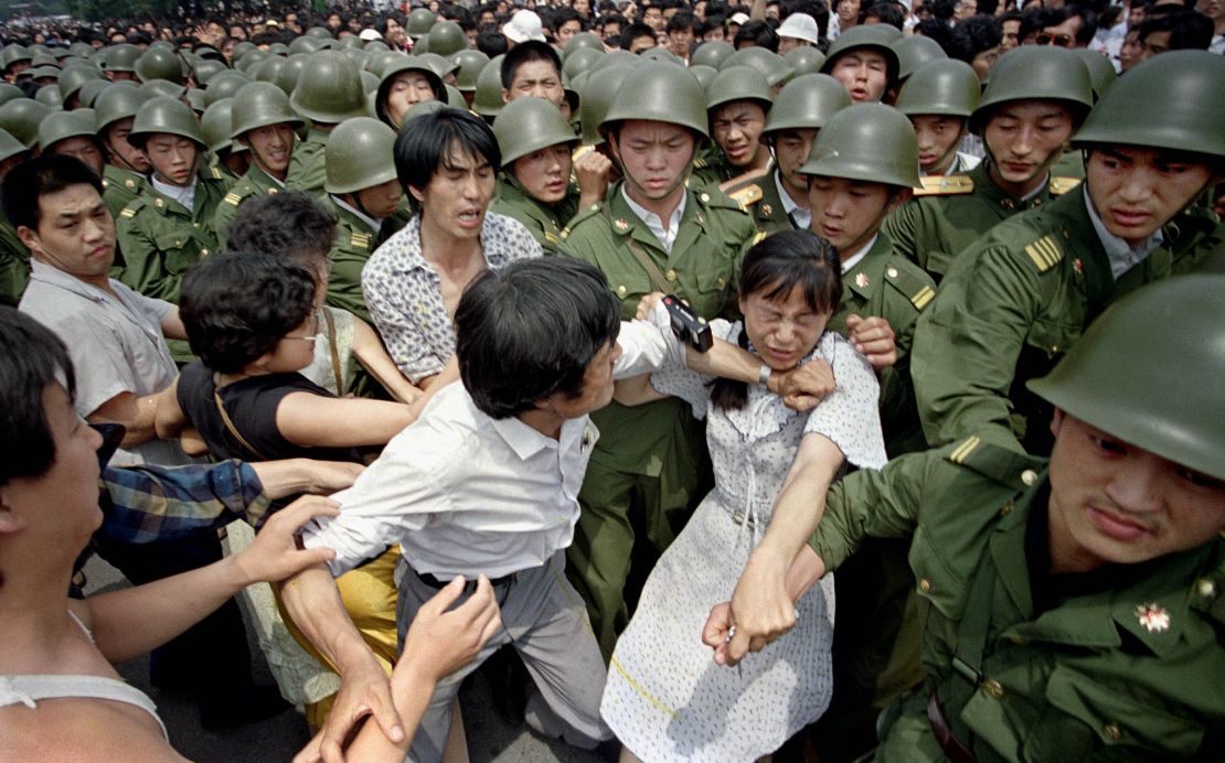 A young woman is caught between civilians and Chinese soldiers near the Great Hall of the People in Beijing, June 3, 1989.