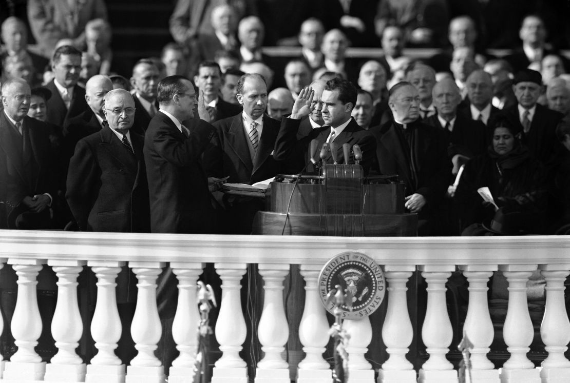 A tight-lipped outgoing President Harry Truman stands at left as Richard Nixon, right, raises his right hand to be sworn in as vice president of the United States by Sen. William Knowland of California on January 20, 1953, in Washington, DC.