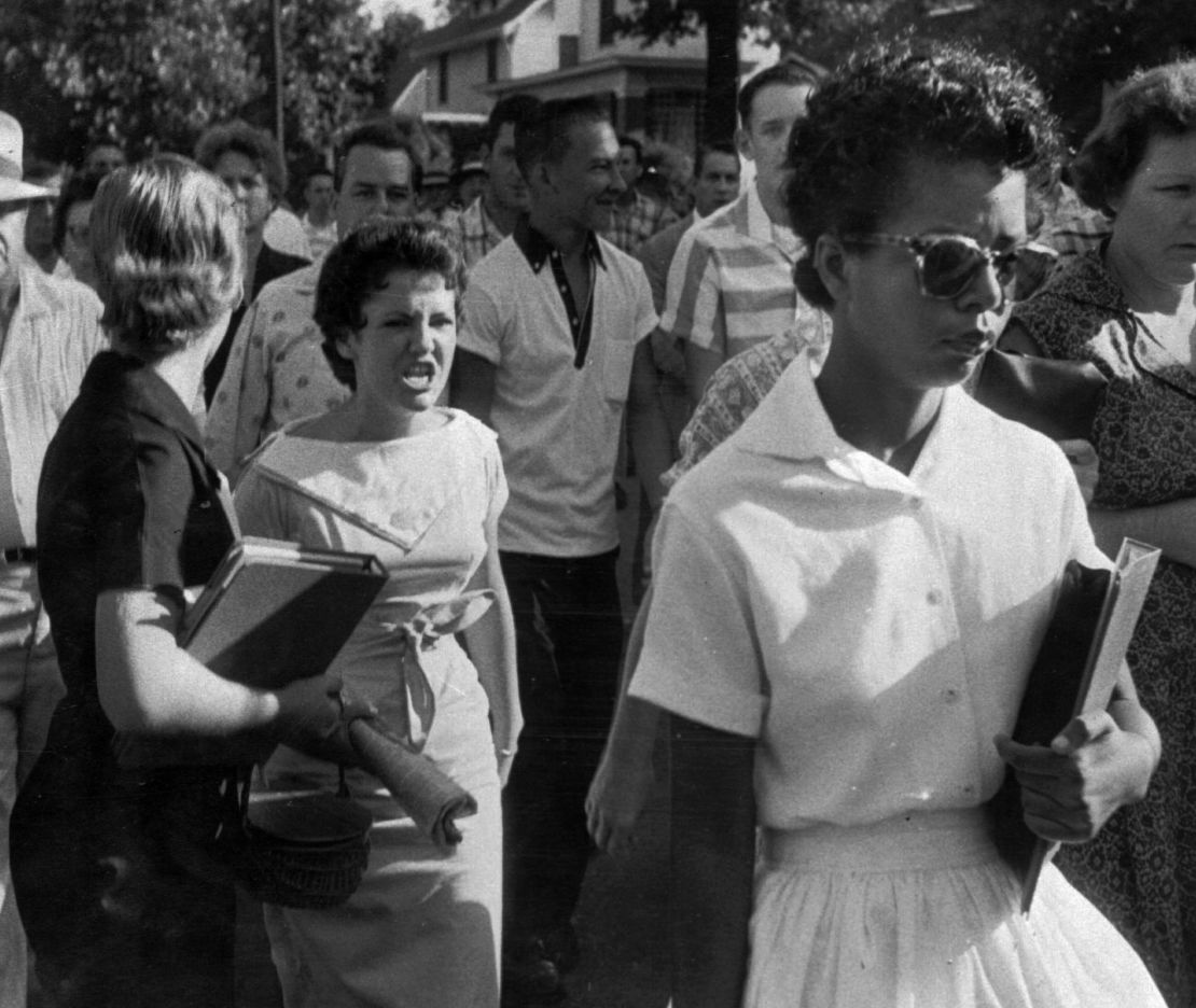 Hazel Bryan, center left, and other students of Central High School in Little Rock, Arkansas, shout insults at Elizabeth Eckford as she calmly walks to a line of National Guardsmen who blocked the main entrance and would not let her enter on September 4, 1957.