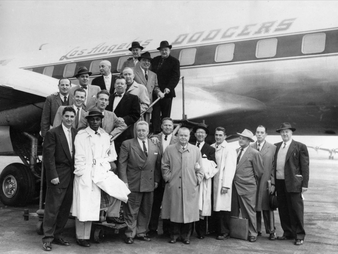 Officials and staff of the Brooklyn Dodgers pose in front of the club's plane at La Guardia in New York before taking off for Los Angeles on October 23, 1957.