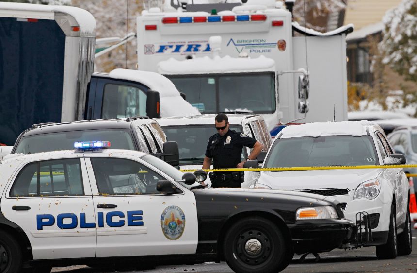 A Westminster Police Officer is surrounded by police vehicles at the Siggs' home, where investigators spent the day gathering evidence in Westminster, Colorado, on October 25, 2012.