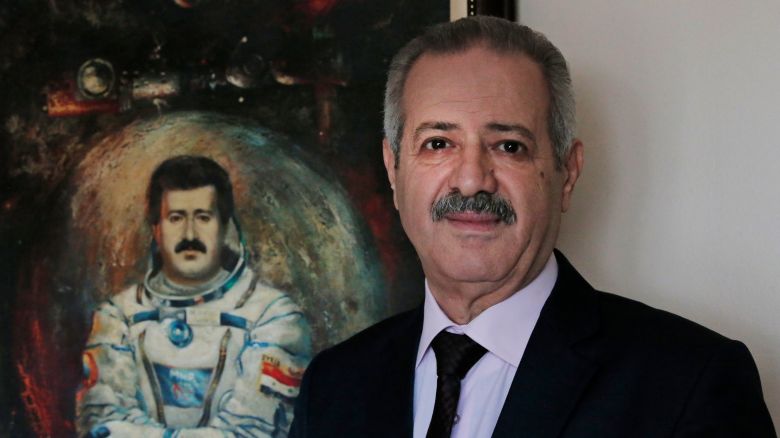 Syrian Mohammad Faris, Syria's first cosmonaut and a former general of the Syrian Air Force, backdropped by a paining of him depicting him with a space suit, smiles as he poses for the photographer in Istanbul, Monday, March 7, 2016. Gen. Mohammed Faris made history and turned into a national hero in 1987, when he became Syria's first man in space as part of a Soviet-led mission. Now, as refugee in Turkey, the 64-year-old cosmonaut is critical of Russia's intervention in Syria and wants European nations to help remove Syrian President Bashar Assad from office to bring about an end to the refugee crisis. (AP Photo/Lefteris Pitarakis)