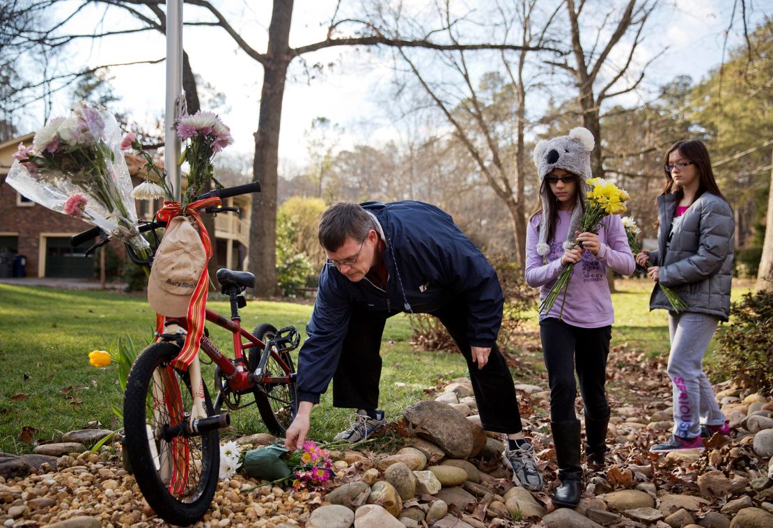 Jason Hoffman places flowers at a makeshift memorial outside the home of Elrey "Bud" and June Runion in January 2015 in Marietta, Goergia.