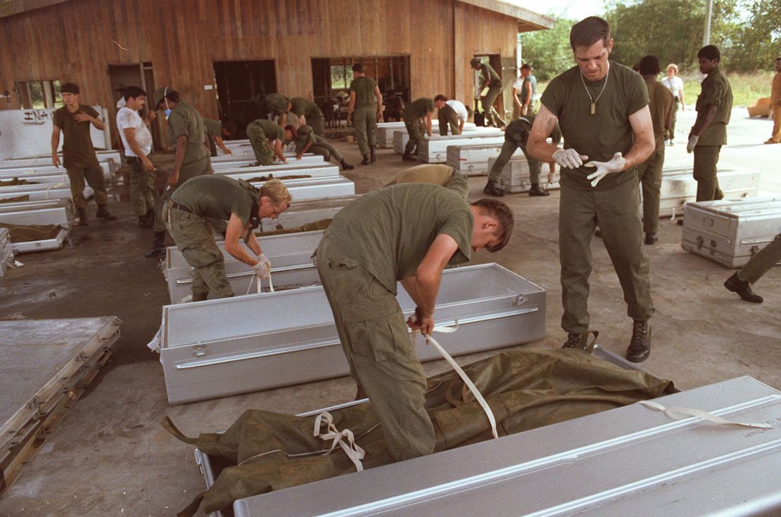 Personal militar estadounidense coloca un cuerpo en un ataúd en el aeropuerto de Georgetown, Guyana, noviembre de 1978.