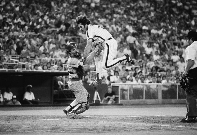 Rose leaps in the air in an attempt to score against Chicago Cubs catcher Mike O'Berry in 1980.