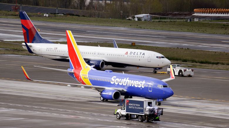 In this photo taken Tuesday, March 24, 2015, a Delta jet is pulled past a Southwest plane at Seattle-Tacoma International Airport in SeaTac, Wash. (AP Photo/Elaine Thompson)
