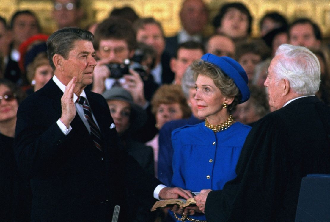 First Lady Nancy Reagan looks on as President Ronald Reagan is sworn in during ceremonies in the Capitol Rotunda in 1985. The ceremony was forced indoors by the cold.