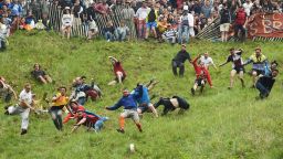 Competitors take part in the annual unofficial cheese rolling race at Cooper's Hill in Brockworth,  England  Monday May 30, 2016. Runners have chased a round of cheese down the 200 yard, one-in-three gradient hill in Brockworth annually, since the early 1800s. (Joe Giddens/PA via AP) UNITED KINGDOM OUT   NO SALES   NO ARCHIVE