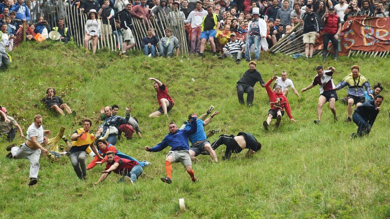 Competitors take part in the annual unofficial cheese rolling race at Cooper's Hill in Brockworth,  England  Monday May 30, 2016. Runners have chased a round of cheese down the 200 yard, one-in-three gradient hill in Brockworth annually, since the early 1800s. (Joe Giddens/PA via AP) UNITED KINGDOM OUT   NO SALES   NO ARCHIVE
