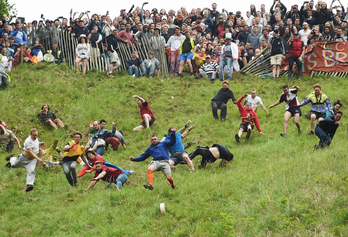 Competitors take part in the annual Cooper's Hill cheese rolling race in Brockworth, England.