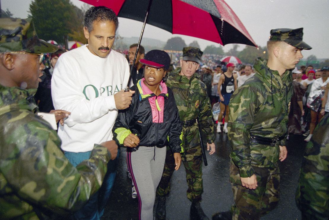 US Marine Corps personnel escort Oprah Winfrey and her partner Stedman Graham to the starting line of the 19th Marine Corps Marathon on October 23, 1994.