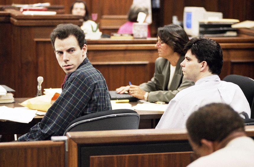 Erik Menendez, left, looks back at spectators in the audience as his brother Lyle, right, sits, during their 1995 retrial.