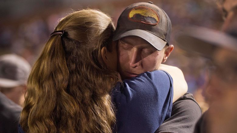 Firefighter Brendan McDonough embraces a mourner near the end of a candlelight vigil in Prescott, Ariz. on Tuesday, July 2, 2013. McDonough was the sole survivor of the 20-man Granite Mountain Hotshot Crew after an out-of-control blaze killed the 19 on Sunday near Yarnell, Ariz. (AP Photo/Julie Jacobson)