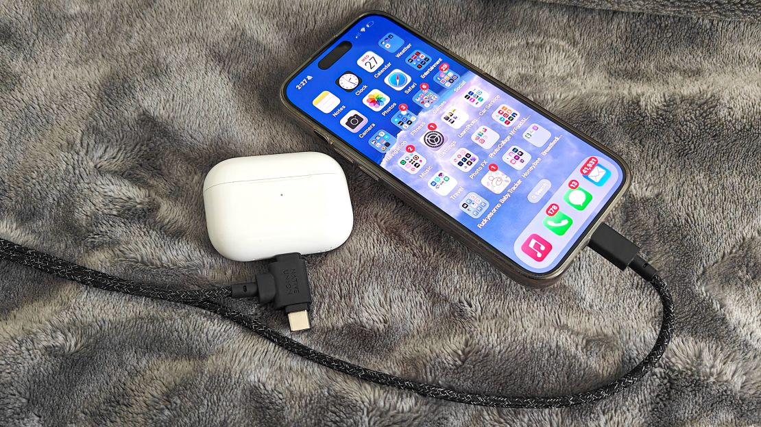 An iPhone plugged into a cord that is also plugged into an AirPods Pro case.